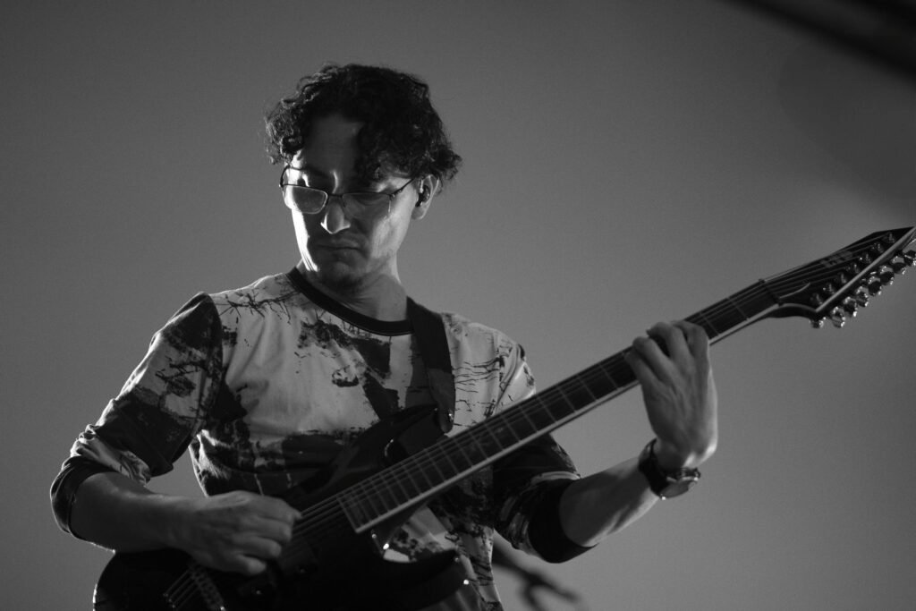 Alexis Jarrín tocando la guitarra en vivo con DAM